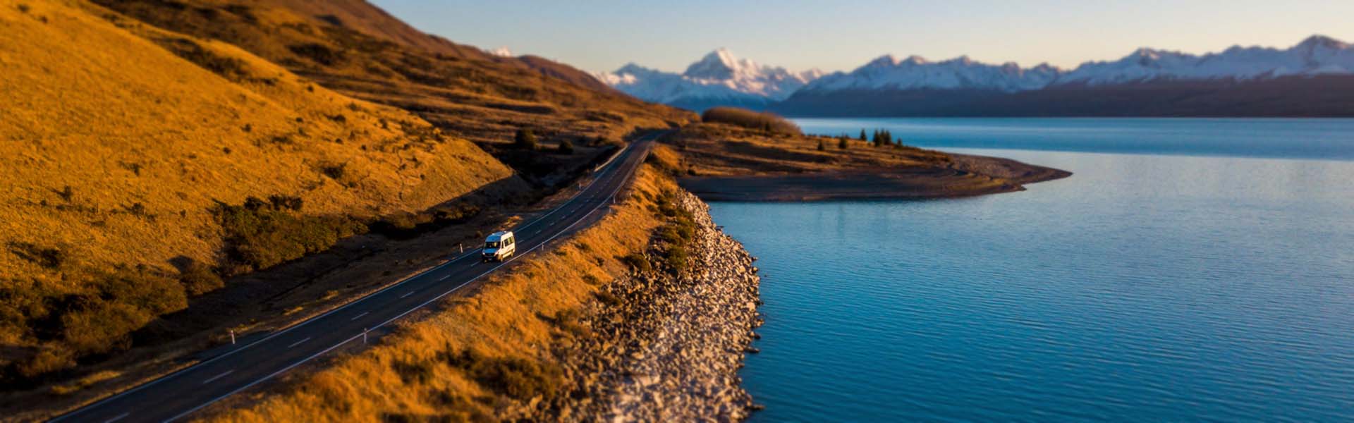 Drone image of campervan driving along water