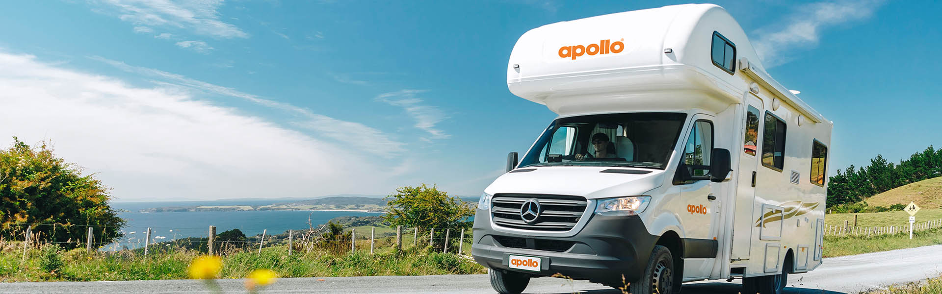 Apollo motorhome driving alongside NZ coastline