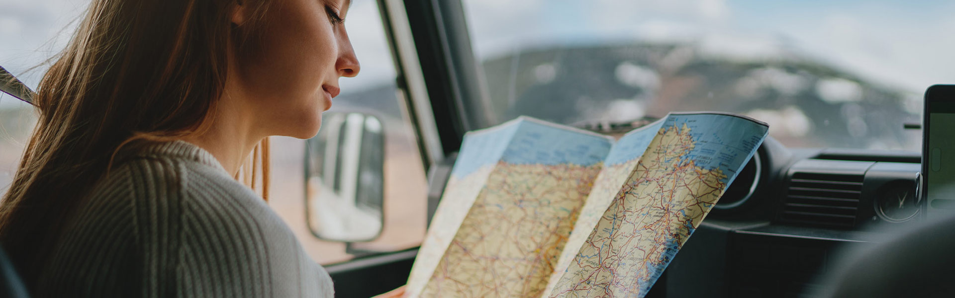 woman looking at map on road trip