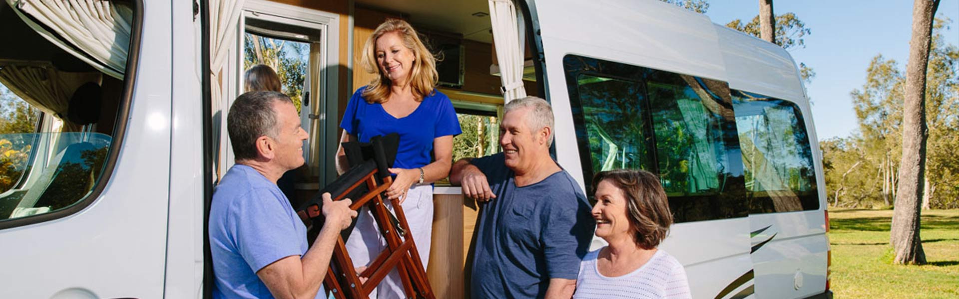 grey nomads in front of Apollo campervan 