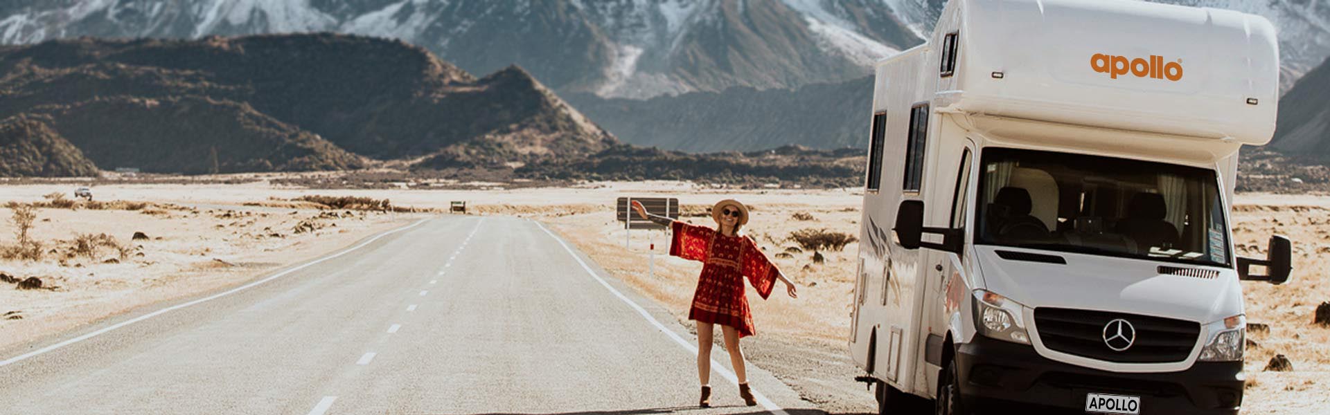 Woman standing in front of Apollo motorhome in New Zealand